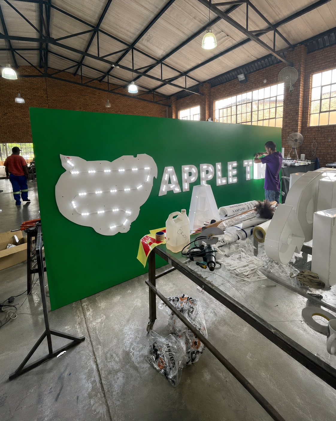 DSP staff assembling illuminated signage inside the Dynamic Signs & Print production facility in Springs, Gauteng.