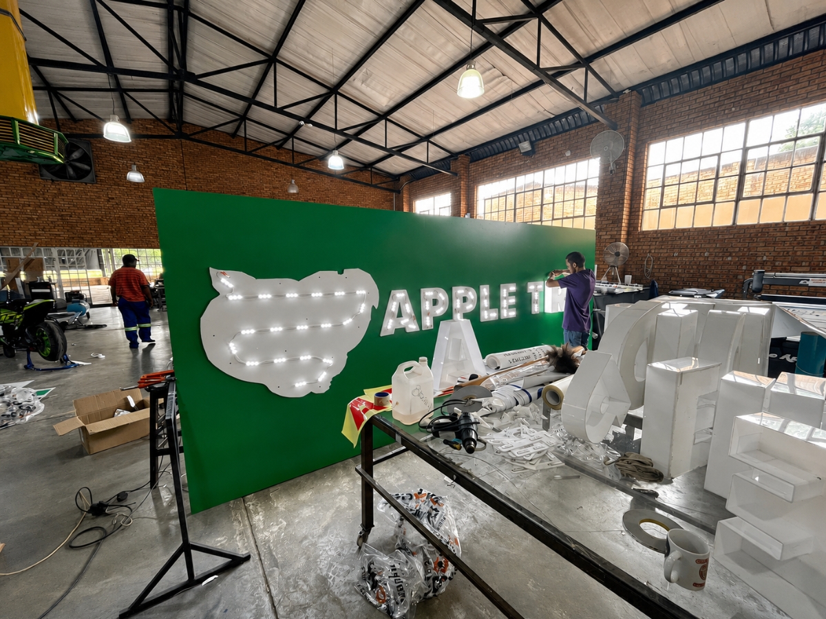 DSP team assembling illuminated channel-letter signage inside the production facility